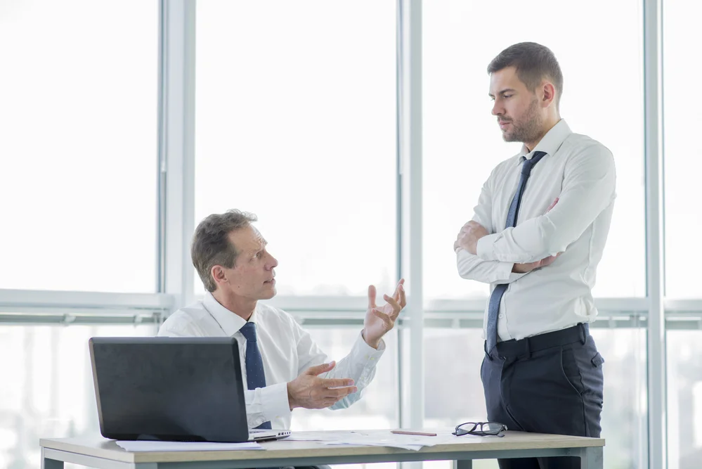 Executivos discorrendo sobre algum assunto. É fácil notar a a linguagem não-verbal.