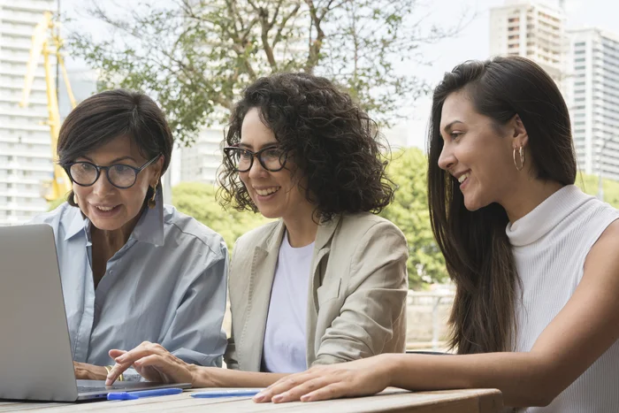 Trio de executivas discutindo sobre os desafios e oportunidades do mundo corporativo