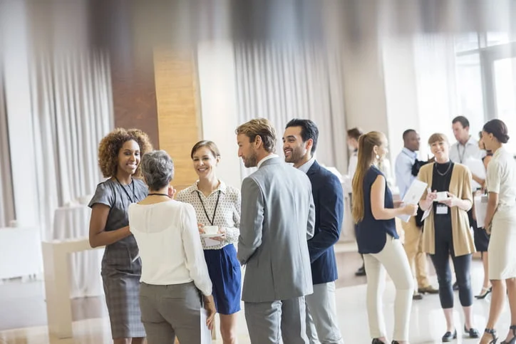 Executivos em auditório. em pé, exercitando o que aprenderam sobre comunicação efetiva. 