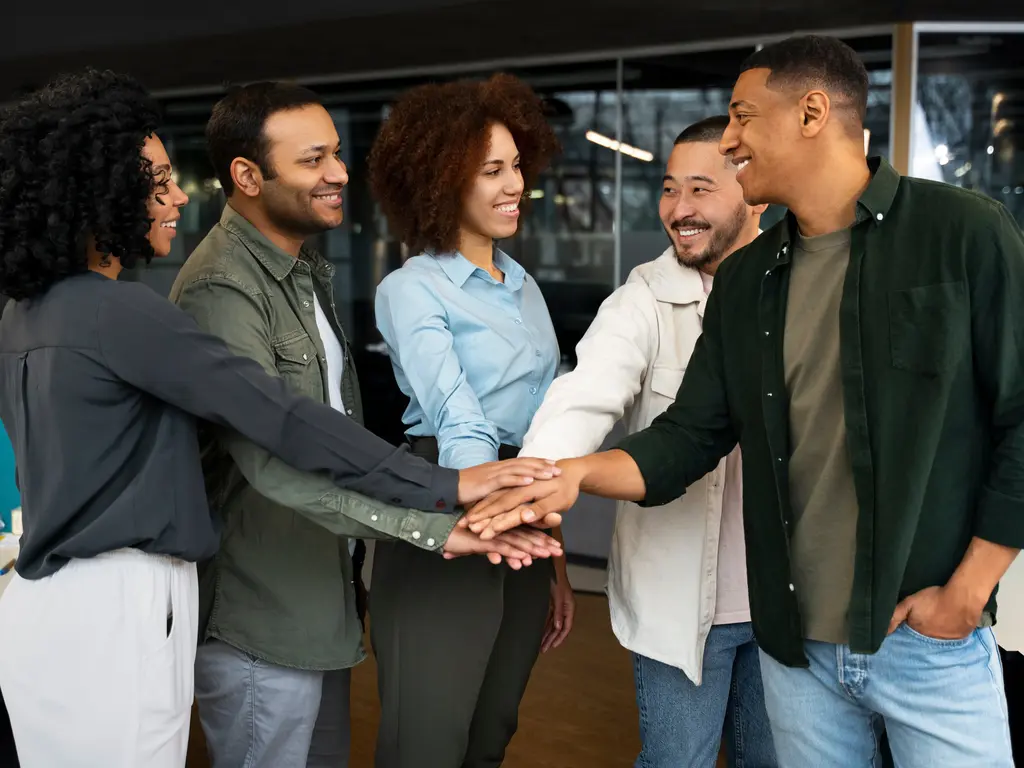 Equipe unida com mãos unidas - representando a forma de uma liderança democrática. 