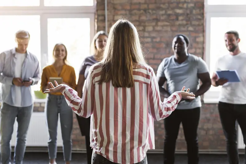 Mulher liderando equipe em startup promovendo liderança humanizada.