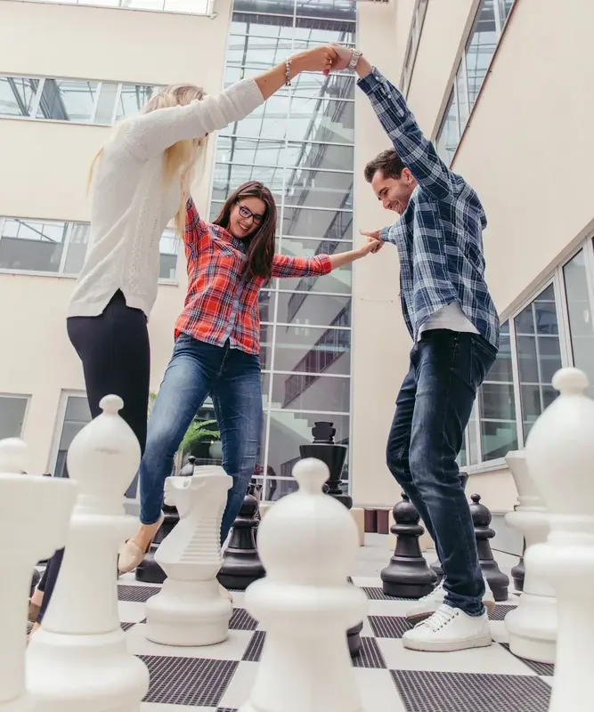 Liderança Autocrática e alta performance Equipe de mãos dadas comemorando resultados após ação de liderança autocrática.