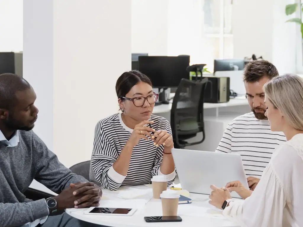 Liderança Democrática na Prática Equipe trabalhando em mesa redonda - sem cabeceiras. Representa uma espécie de liderança democrática.