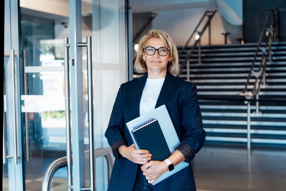 Mulher em ambiente corporativo representando lideran&ccedil;a e alta dire&ccedil;&atilde;o.